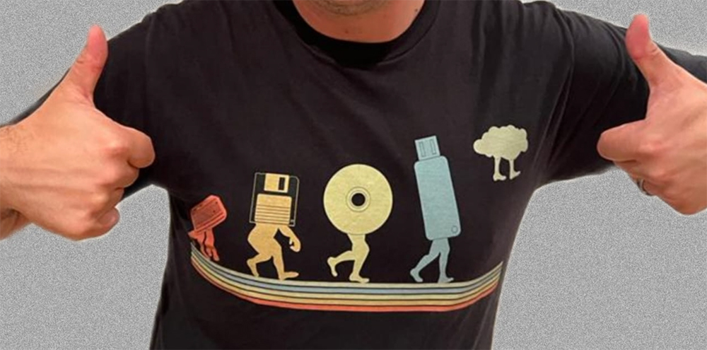 T-shirt showing storage media walking in line, from cassette and floppy disk to CD, USB stick and the cloud