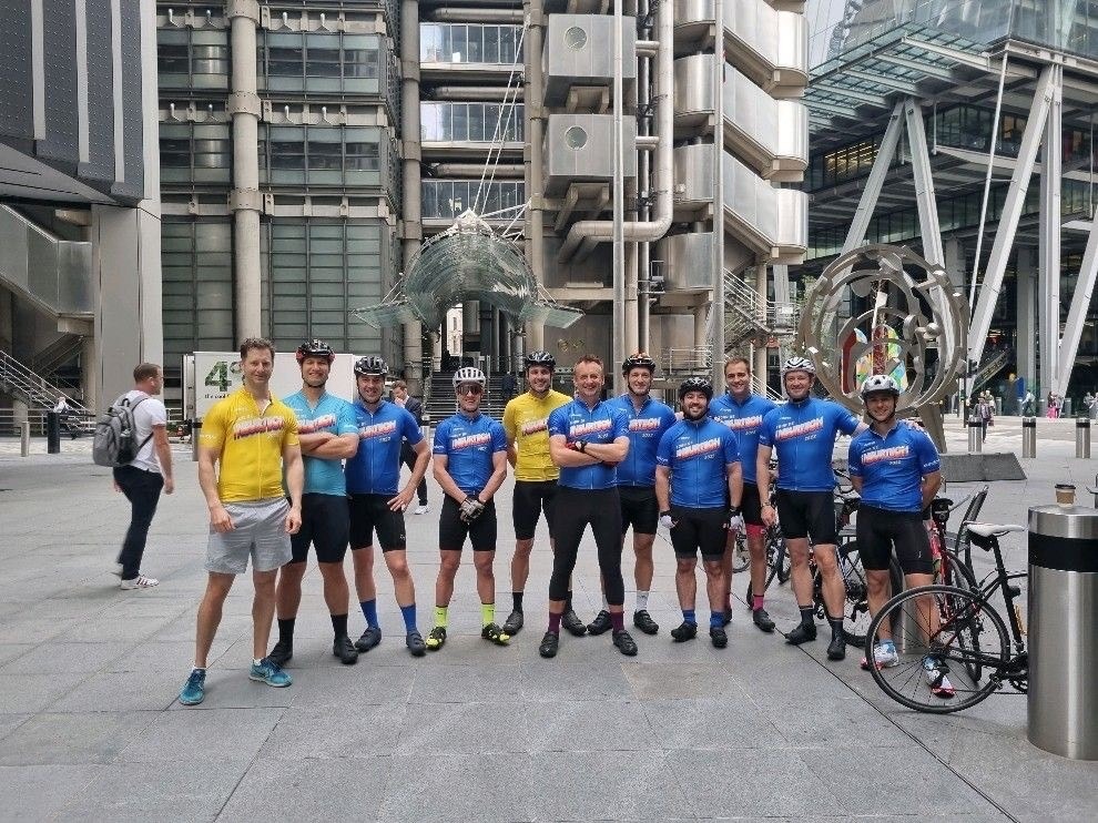 Tour de Insurtech riders in team jerseys outside the Lloyd's building in London