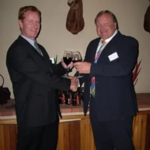 Two colleagues raising a toast with red wine at an early Genasys event