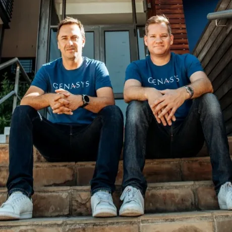 Two colleagues sitting on steps outside a Genasys office