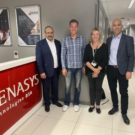 Four colleagues standing in a Genasys reception area