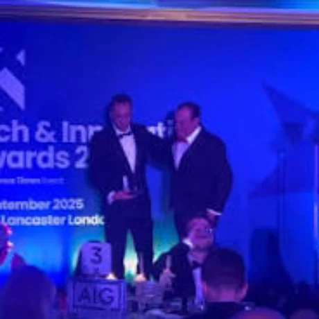 Two colleagues on stage at the Insurance Times Tech and Innovation Awards, one holding a trophy