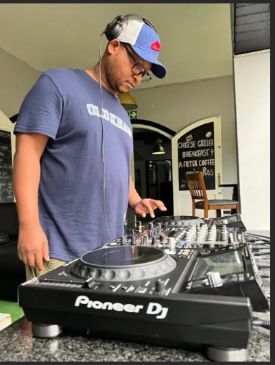 A colleague in a cap and headphones playing a DJ deck