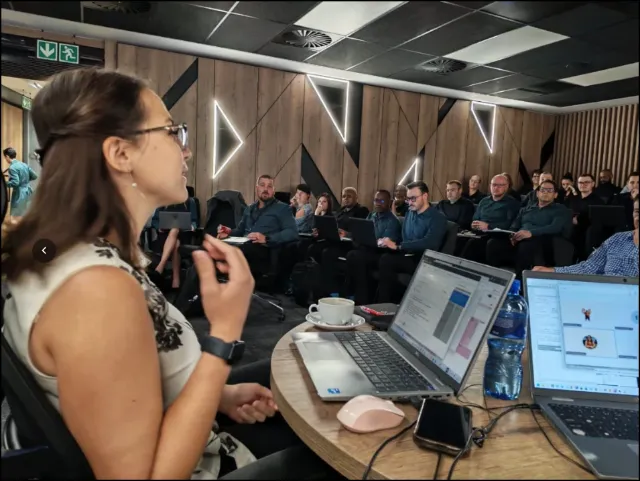 A colleague speaking to a full training room