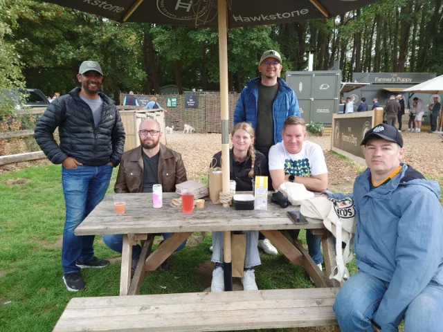 Six colleagues around a picnic table under a parasol